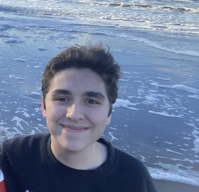 Portrait of CJ staning by the water.