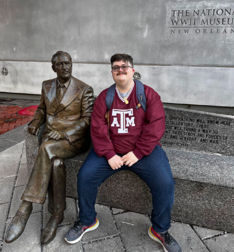 Jake sitting on a bench next to a statue